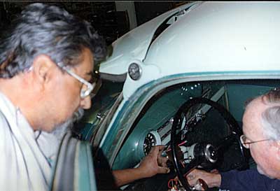 Owner Rudy Escalera helps Larry Myers with steering wheel column work.